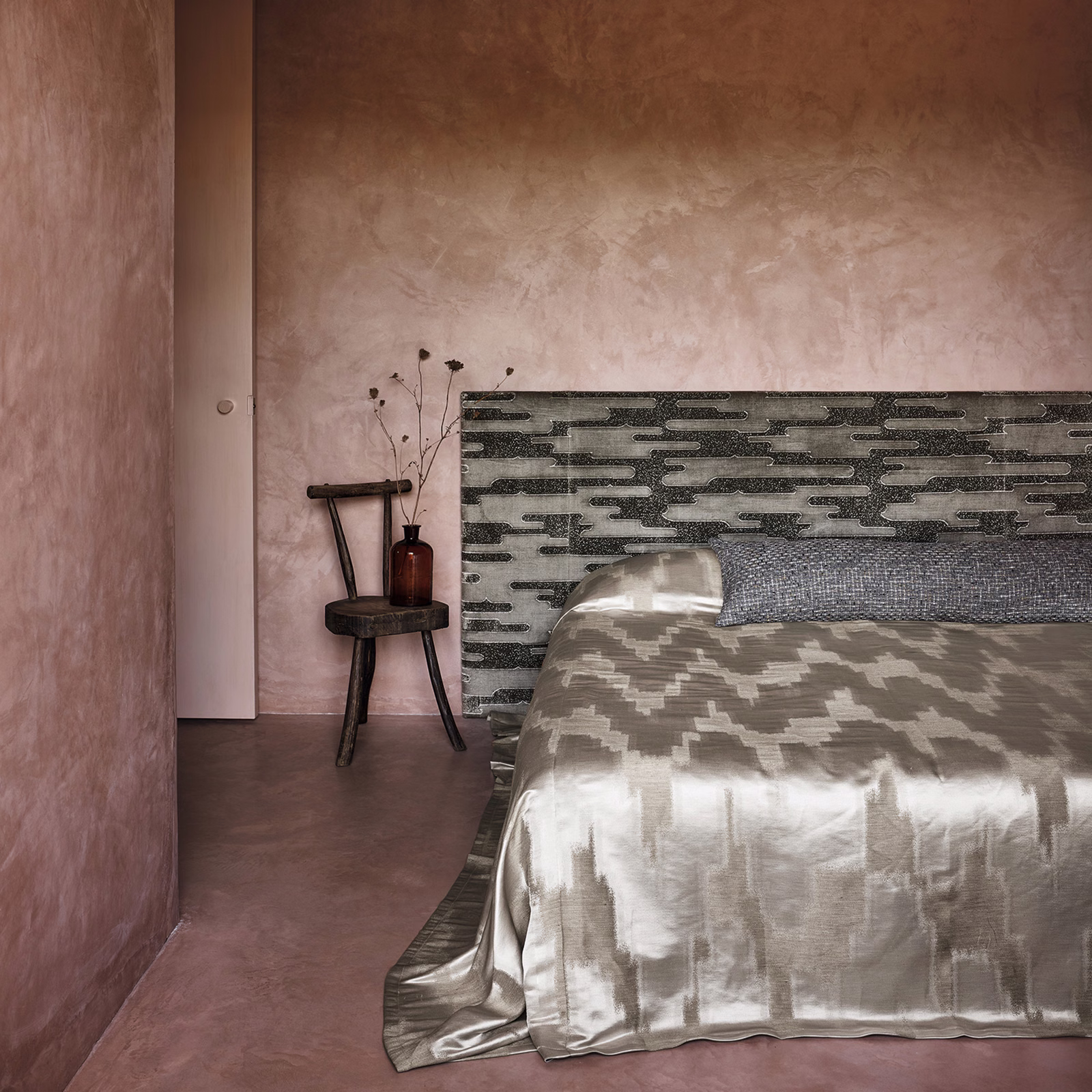 Lustrous mineral taupe-grey fabric with irregular horizontal bands draped across a bed