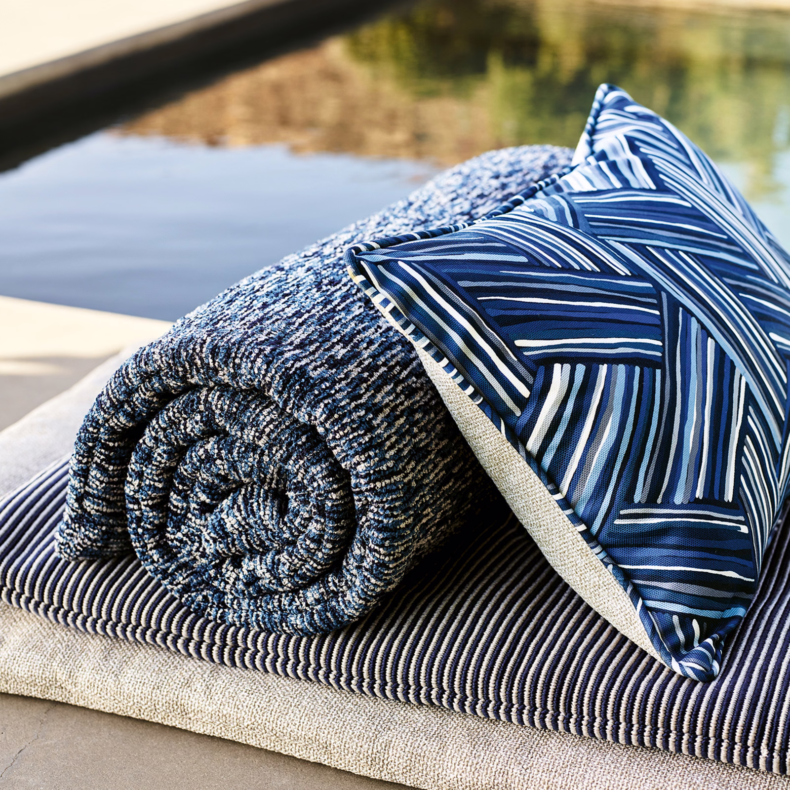 Deep ocean blue fabric with angular white and blue linear pattern on outdoor cushion