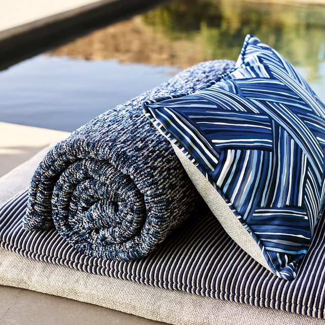 Deep ocean blue fabric with angular white and blue linear pattern on outdoor cushion