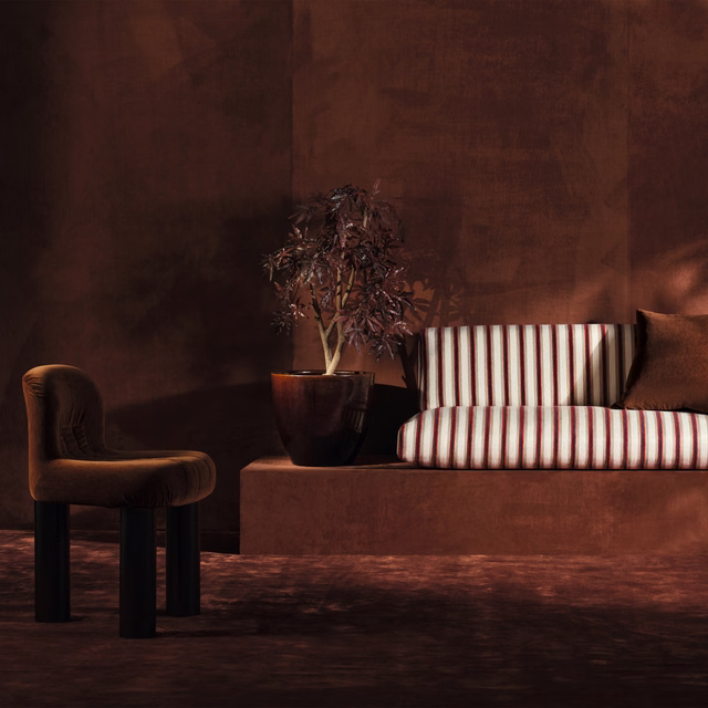 Deep red and ivory vertical striped upholstery on a tailored seat in moody light