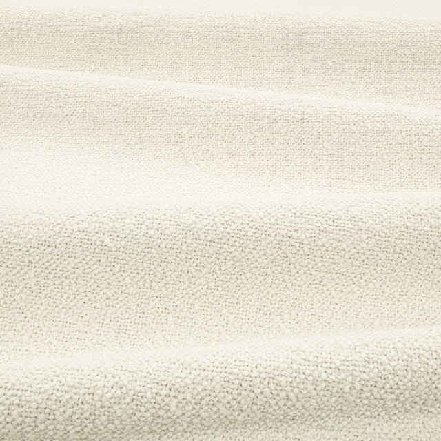 Warm bone bouclé with dense ivory loops and soft horizontal fold shadows