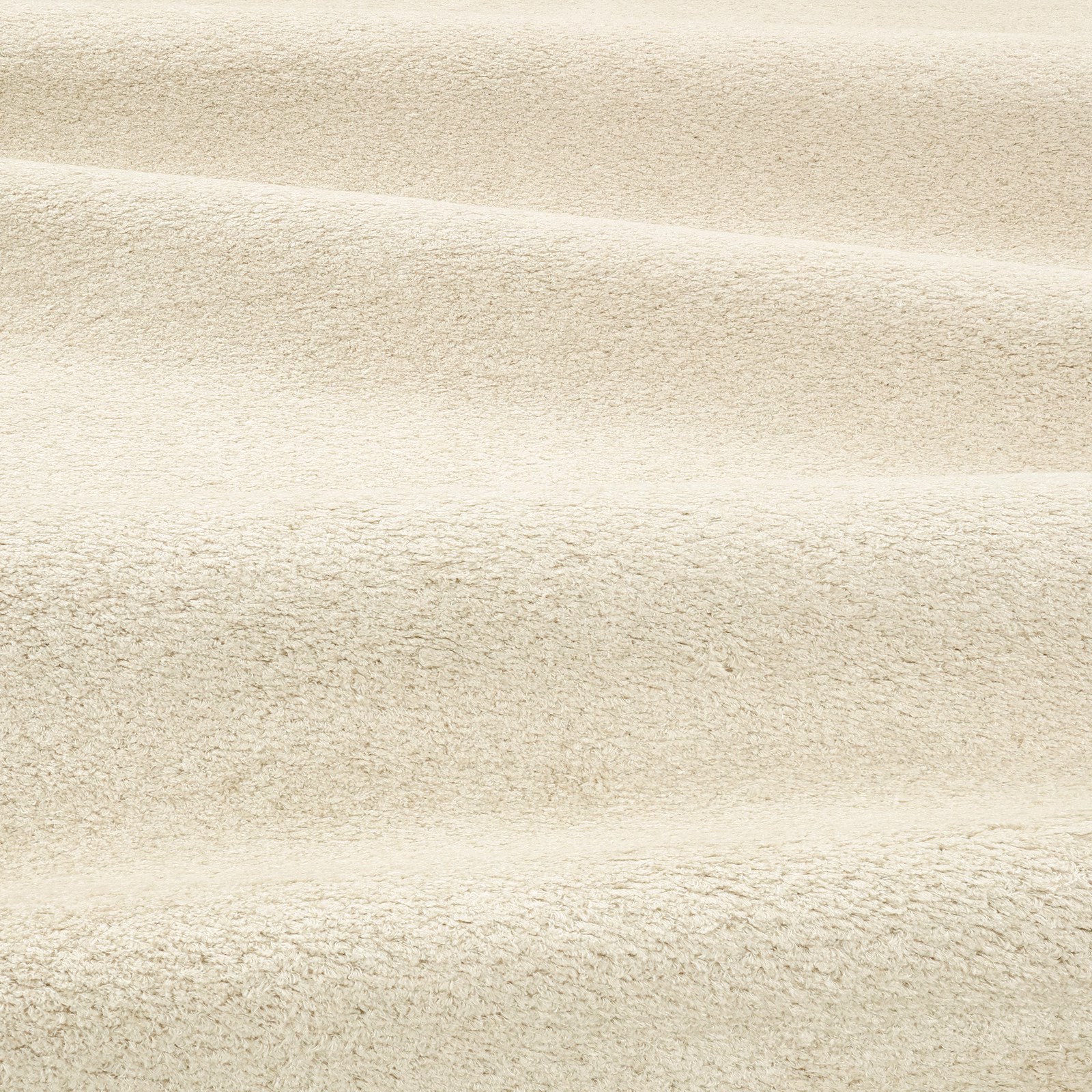 Close-up of pale stone-beige boucle fabric with soft horizontal folds and nubby texture
