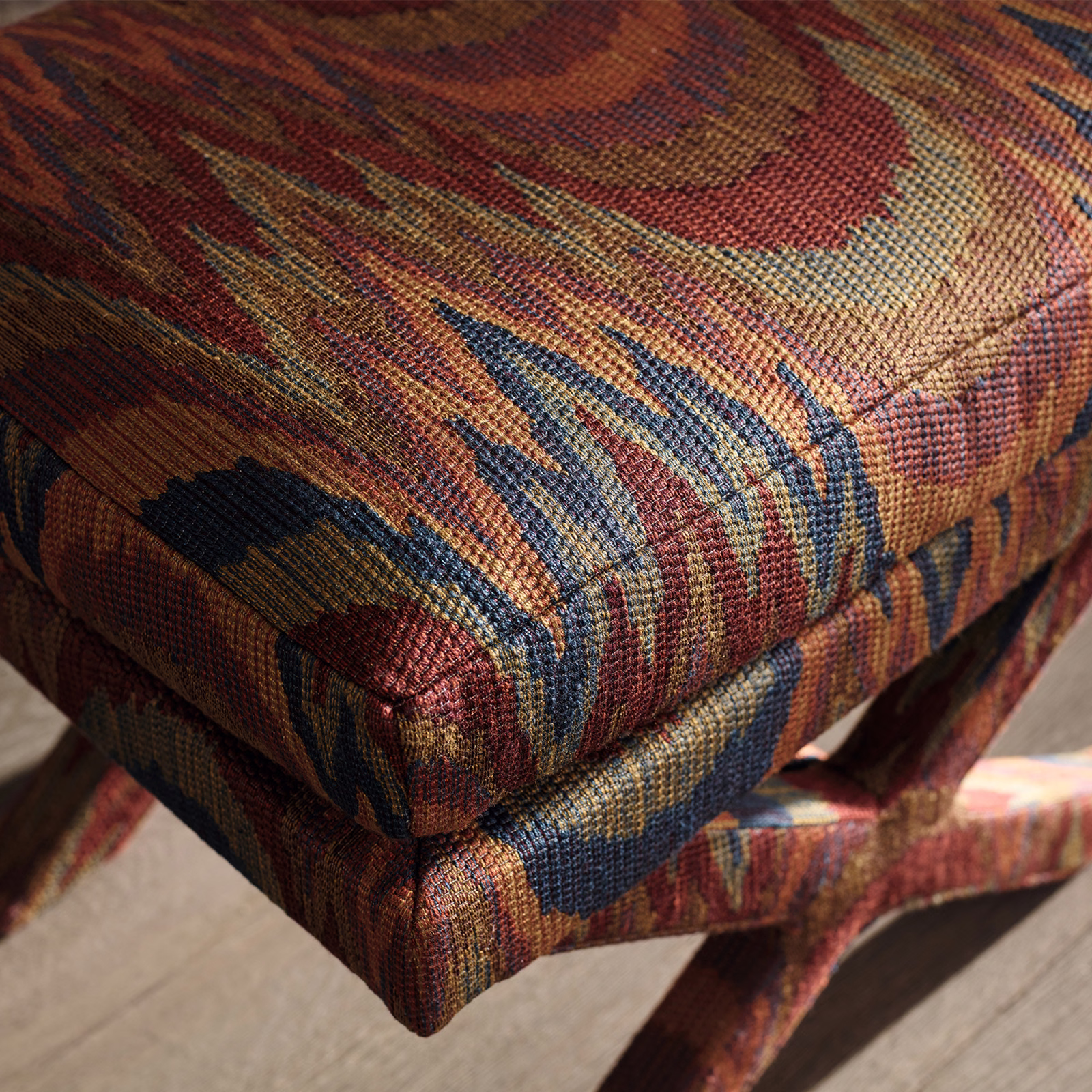 Rust, ochre, blue and burgundy abstract woven upholstery on stacked cushions