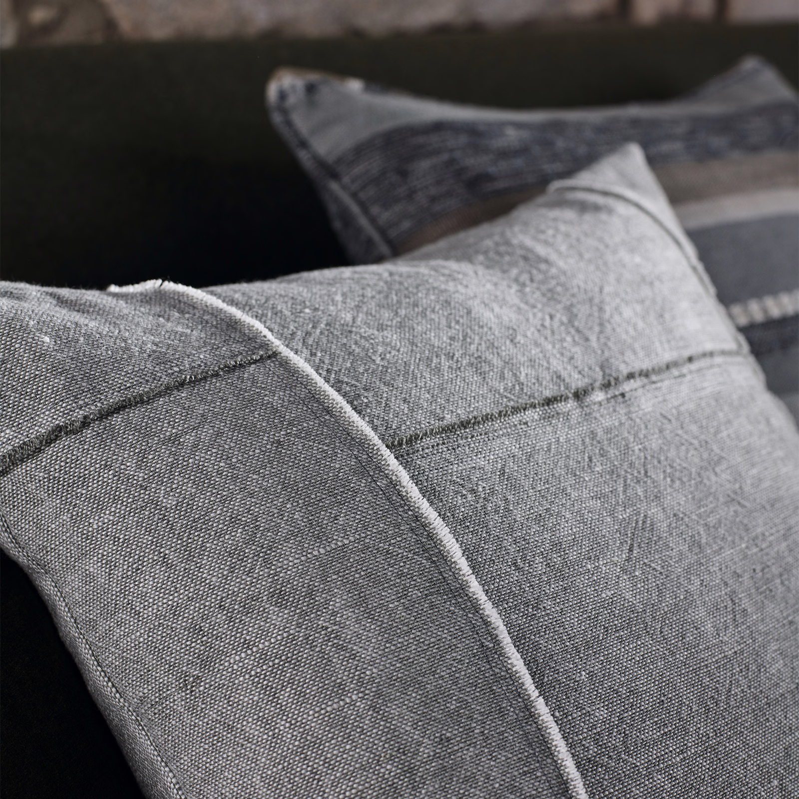 Cool smoke-grey woven fabric on tailored cushions with fine marl texture