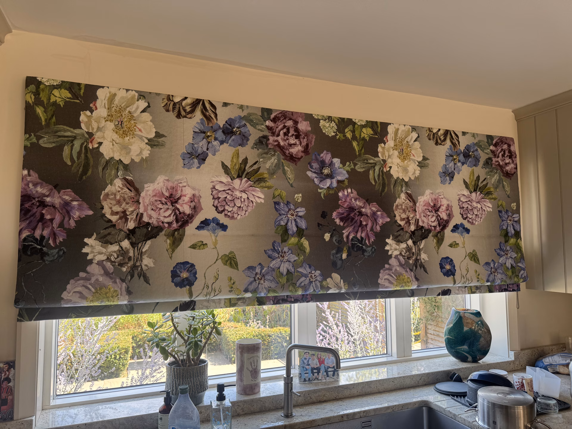 A floral roman blind over a kitchen window