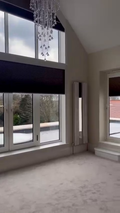 An electric gable end blind travelling down a tall angled window