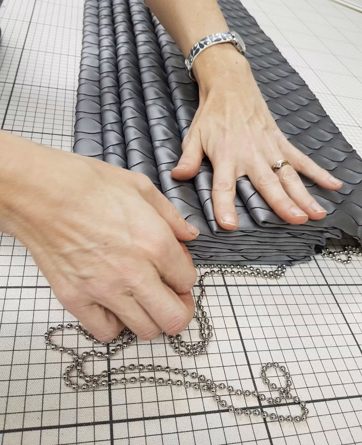 Hand pleating a blind on the workshop bench