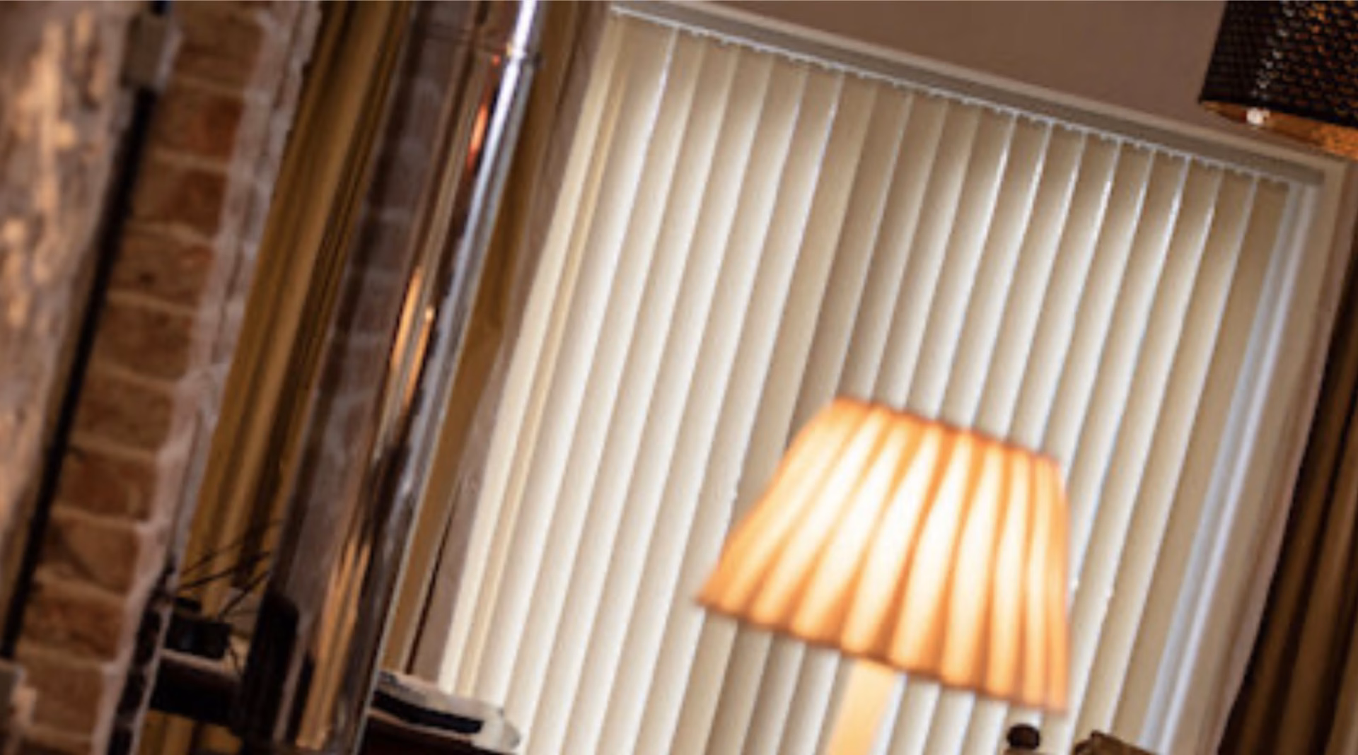 Vertical blinds beside a lamp