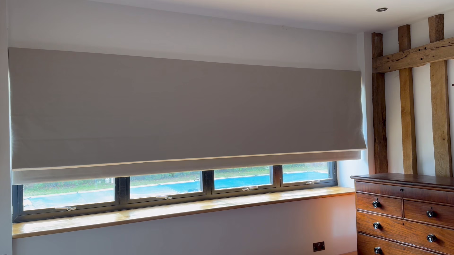 A three and a half metre motorised roman blind coming down a wide window