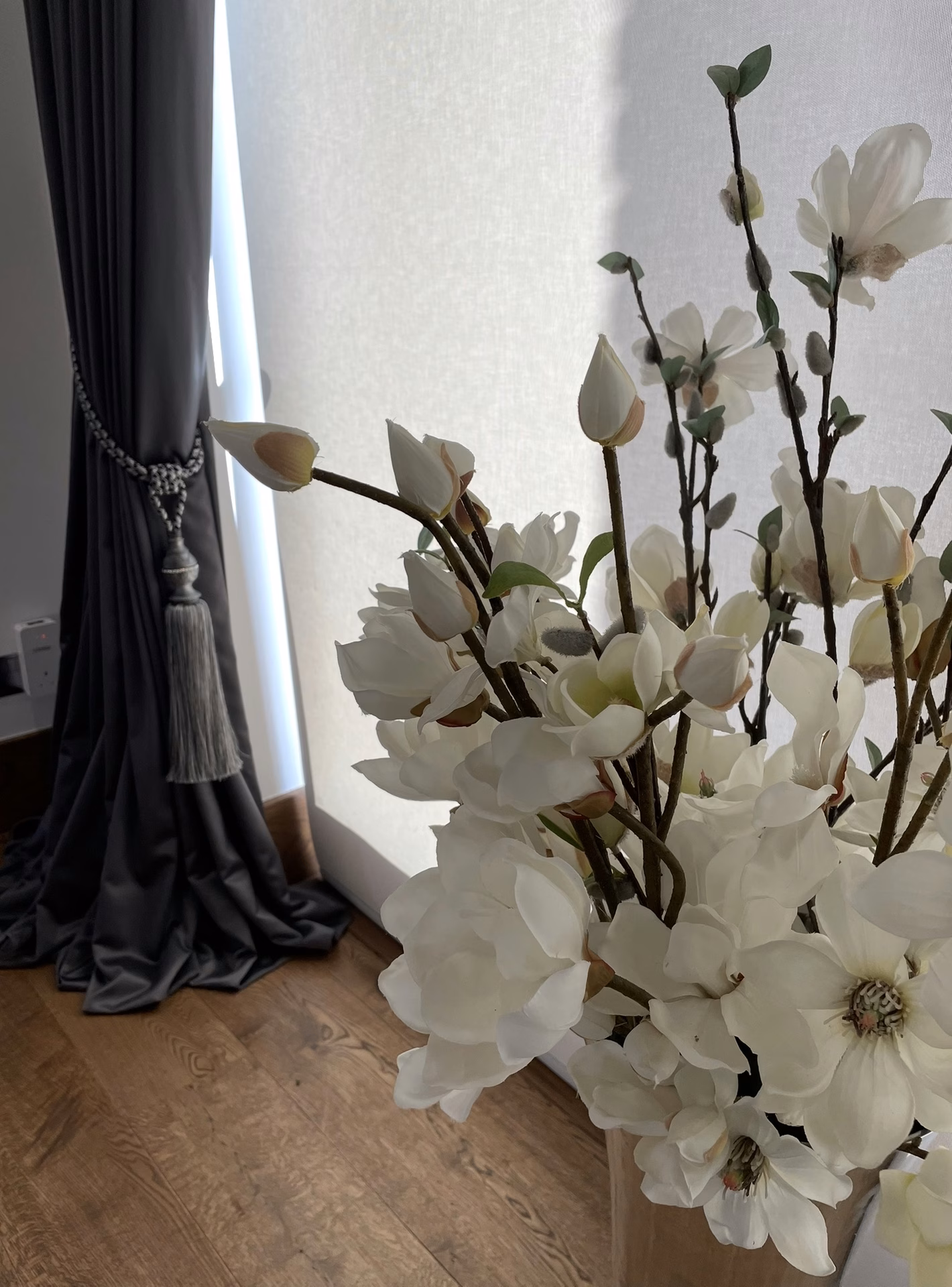 A grey curtain held back with a tieback