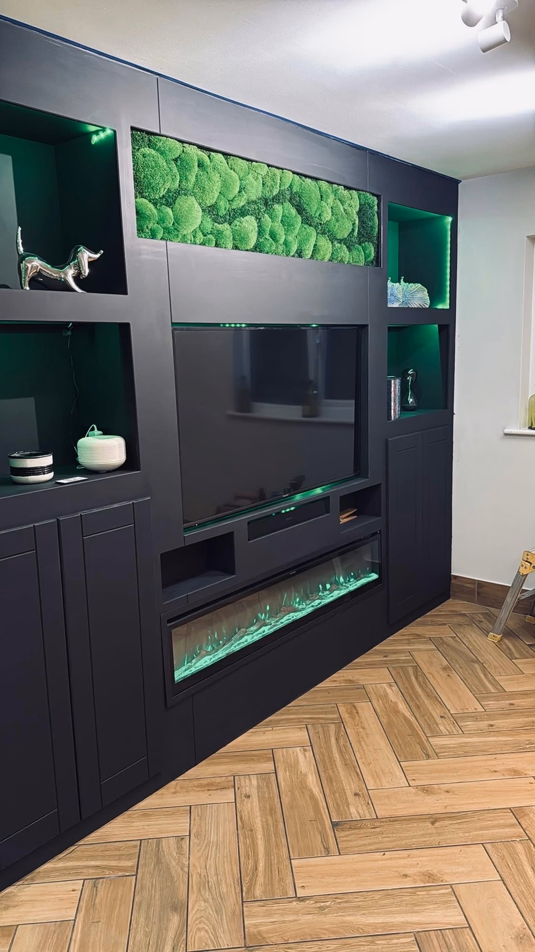 A preserved moss panel set into a black media wall