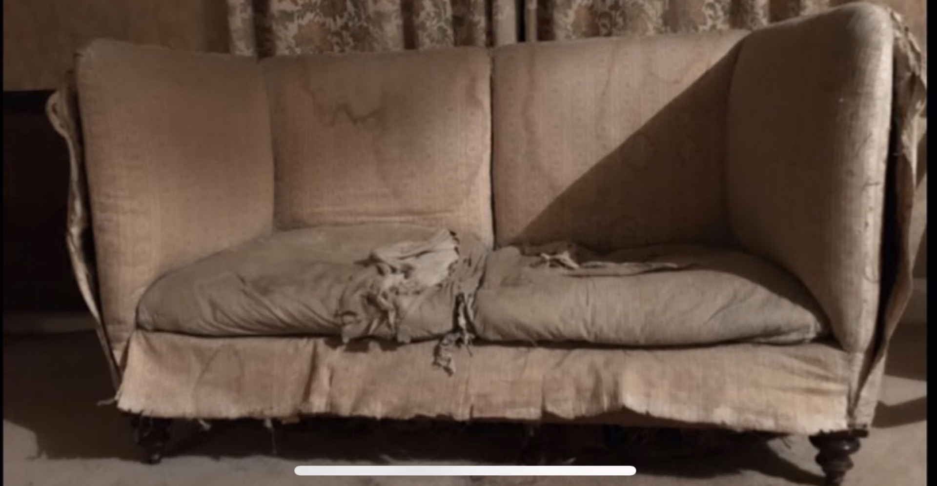 A sofa worn through, before reupholstery