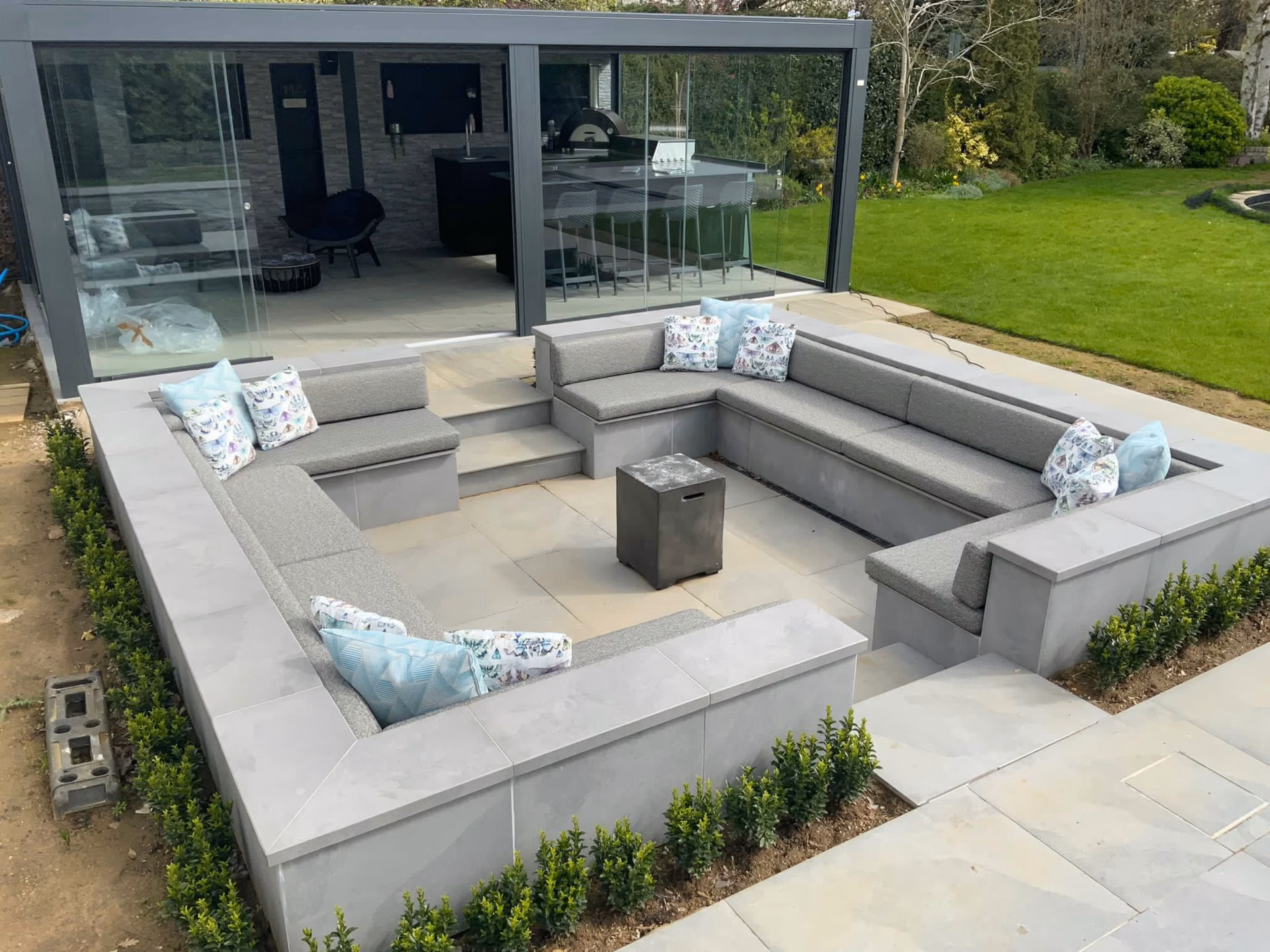 A sunken garden seating area with cushioned benches